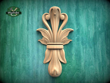 Load image into Gallery viewer, a decorative wooden carving of a stylized flower or plant on a green background.
