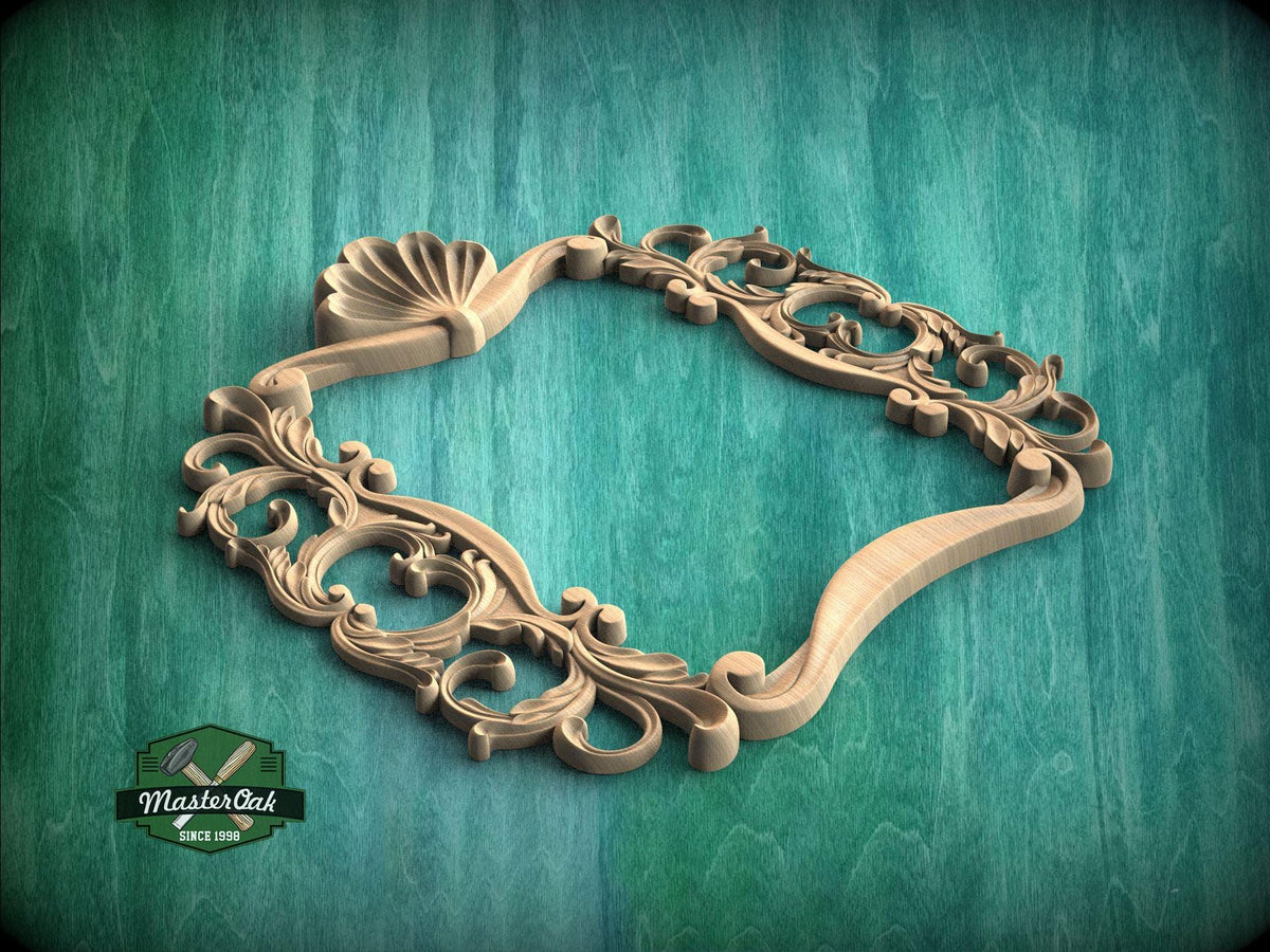 A wooden ornate frame with intricate carvings and designs, resting on a green wooden surface.