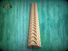 Load image into Gallery viewer, a wooden carving of a decorative scrollwork design on a wooden surface.
