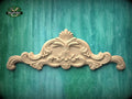 a decorative wooden carving on a green background.