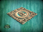 a decorative wooden carving of a musical instrument, surrounded by intricate floral patterns, set against a teal-colored background.