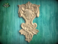 a decorative wooden carving on a green background.