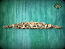 Load image into Gallery viewer, A decorative wooden carving with intricate scrollwork is displayed against a textured green background.
