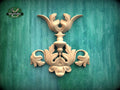 a decorative wooden carving on a green background.