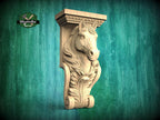 A carved wooden horse head mounted on a green wooden wall.