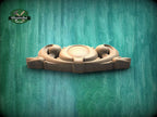 A wooden carving or sculpture is displayed against a green textured background.