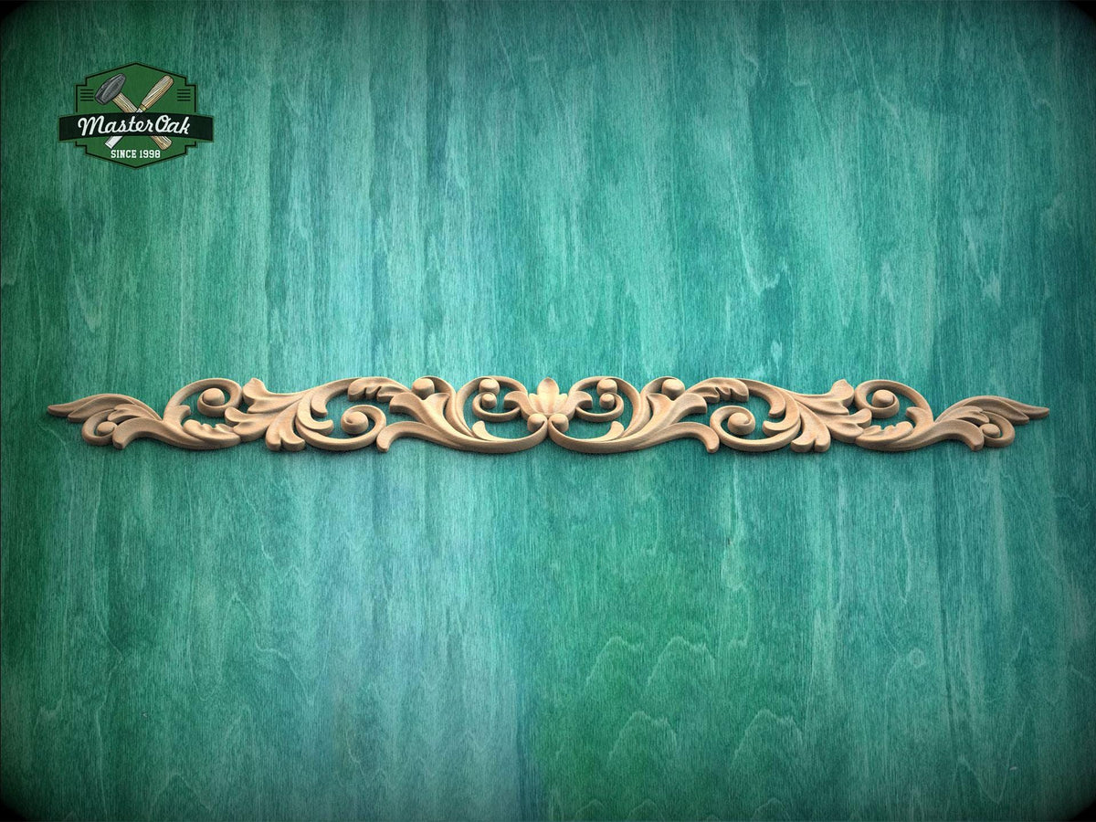 a decorative wooden carving on a green wooden surface.