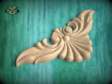 Load image into Gallery viewer, A decorative wooden carving in the shape of a leaf or flower is displayed against a teal background.
