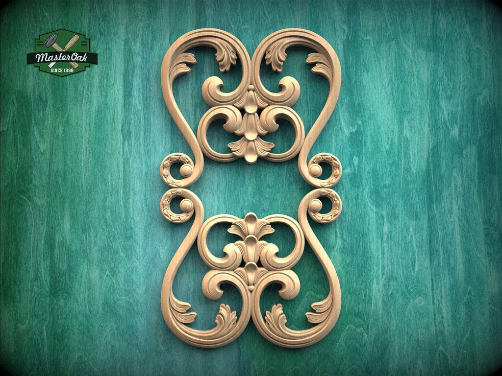 a decorative wooden carving with intricate scrollwork and floral designs, set against a green background.