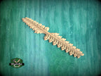 A decorative wooden leaf-like object is displayed against a green textured background.