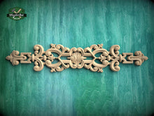 Load image into Gallery viewer, a decorative wooden carving on a green wooden surface.
