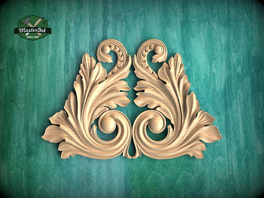 a decorative wooden carving of two ornate leaves or flowers, with intricate scrollwork and a symmetrical design, set against a green background.