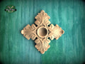 a decorative wooden piece with an intricate design, placed against a green background.
