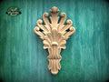 a decorative wooden carving on a green background.