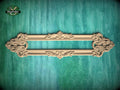 a decorative wooden frame with intricate carvings, displayed against a green textured background.