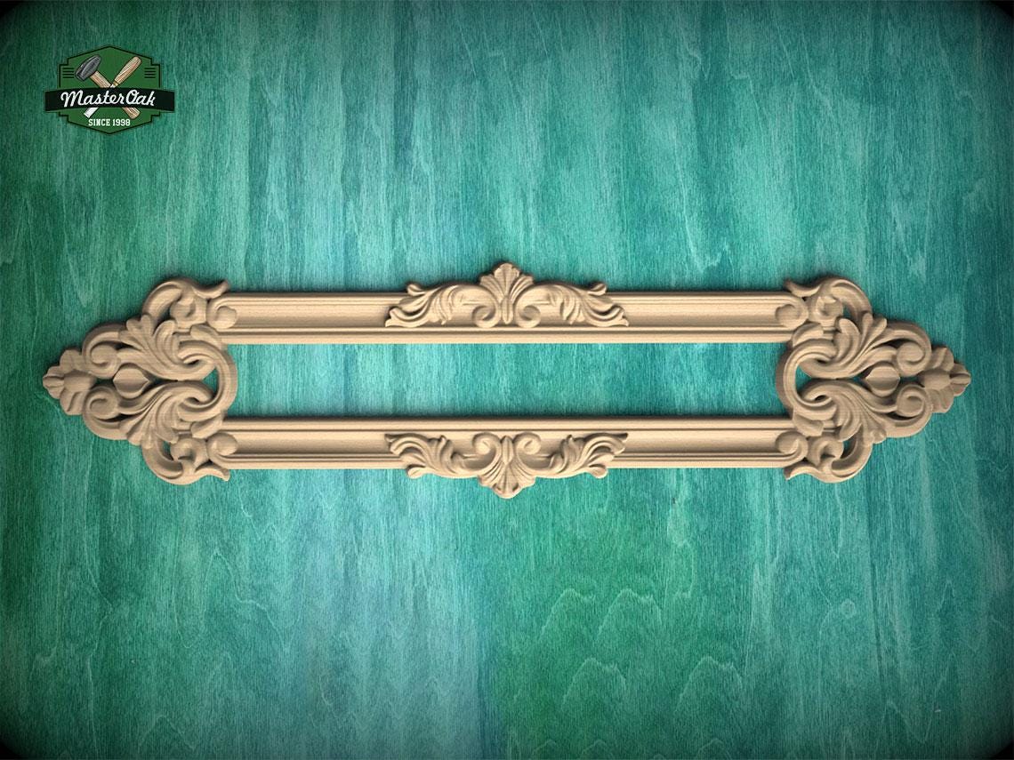 a decorative wooden frame with intricate carvings, displayed against a green textured background.