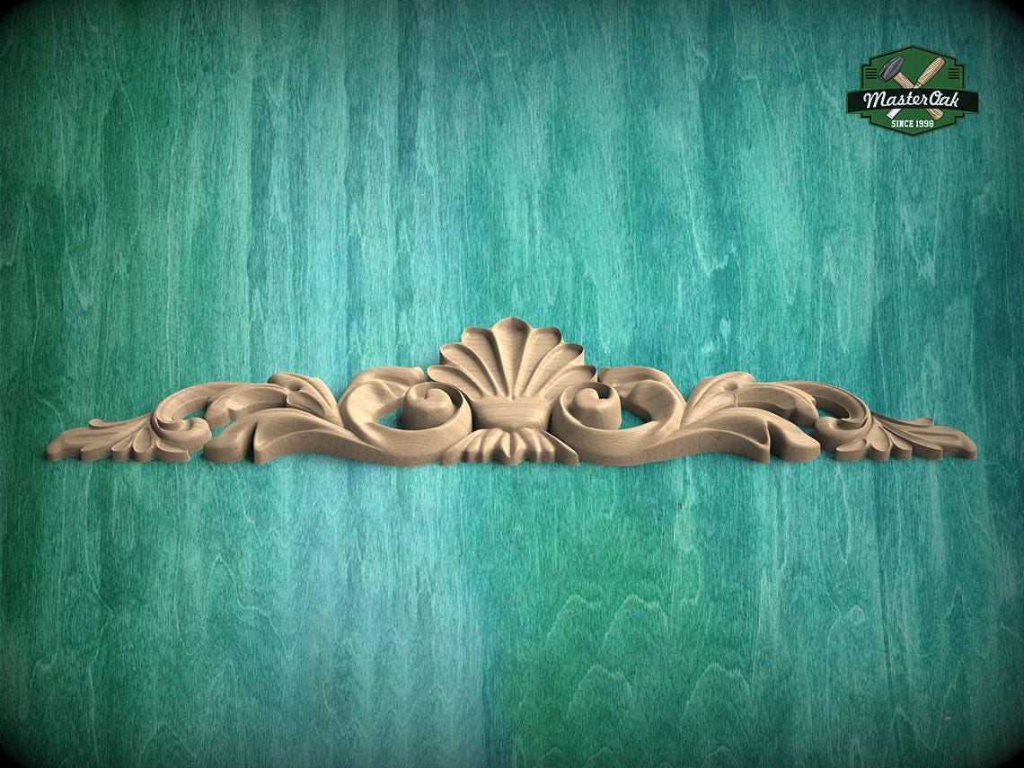 A decorative wooden carving with a shell-like design is displayed against a teal-colored background.