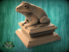 A wooden frog statue sitting on a wooden pedestal against a green background.