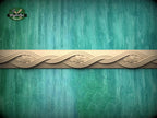 a decorative border made of wood, with a floral design on it, set against a green and blue background.
