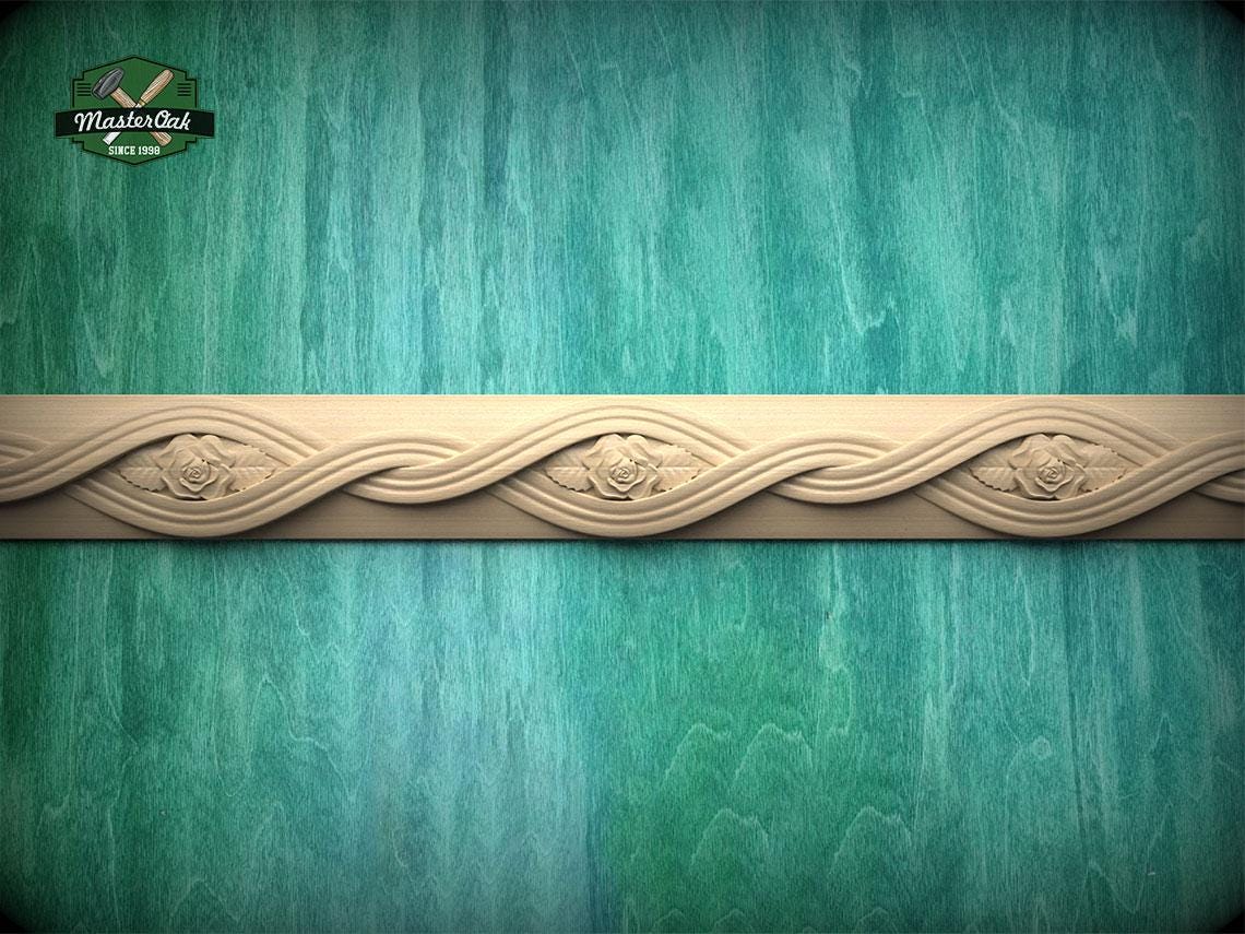 a decorative border made of wood, with a floral design on it, set against a green and blue background.