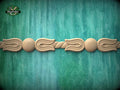 A decorative wooden border with a floral design is displayed against a teal-colored background.