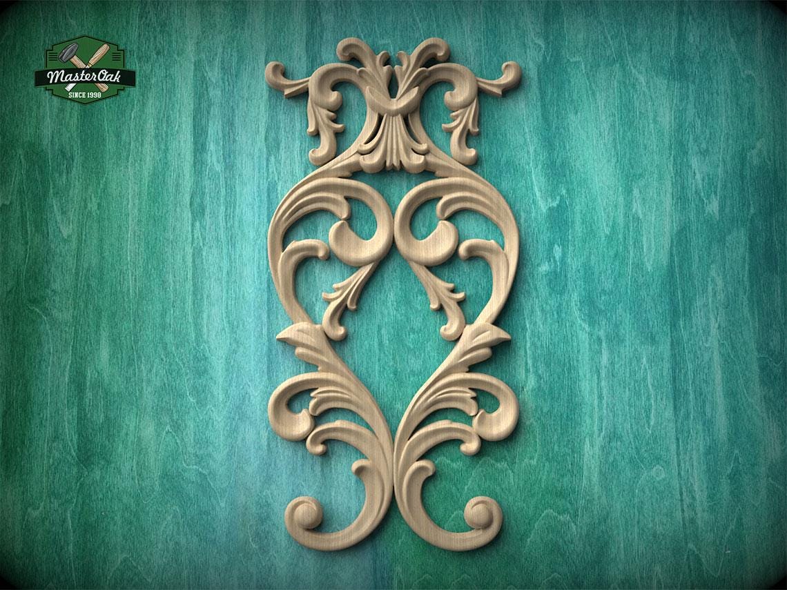 an ornate, carved wooden design with intricate scrollwork and floral patterns, set against a teal-colored background.