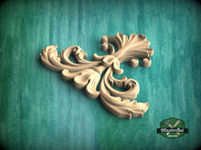 Load image into Gallery viewer, A decorative wooden carving in the shape of a flower or leaf is displayed against a green background.
