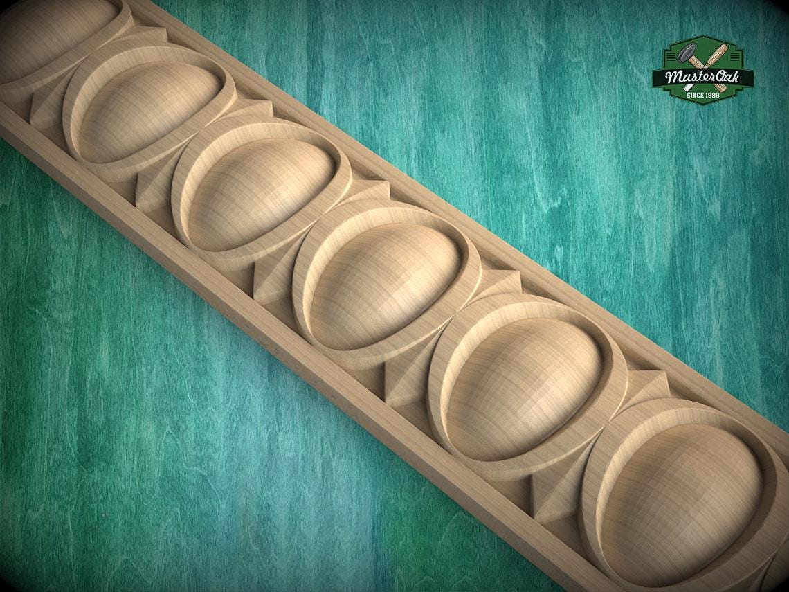 A wooden carving with a repeating pattern of oval shapes is displayed against a green background.