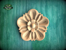 Load image into Gallery viewer, A wooden flower-shaped carving is displayed against a green background.
