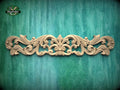 a decorative wooden carving on a green background.