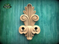 a decorative wooden carving on a green textured background.