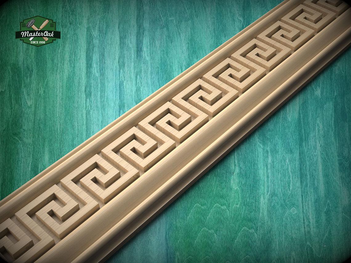 A decorative trim with a repeating geometric pattern in a light wood color, set against a green wooden background.