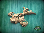 a collection of wooden sculptures or carvings, including a bird-like figure, against a green background.