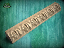 Load image into Gallery viewer, A decorative wooden molding with a repeating floral pattern is shown against a green background.
