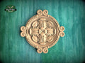 a decorative wooden panel with an intricate floral design, set against a green background.