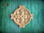 a decorative wooden panel with an intricate floral design, set against a green background.