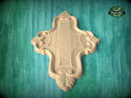 a wooden carving of a cross-shaped design on a green background.