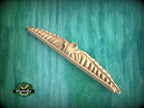 A wooden carving or sculpture is displayed against a green background.