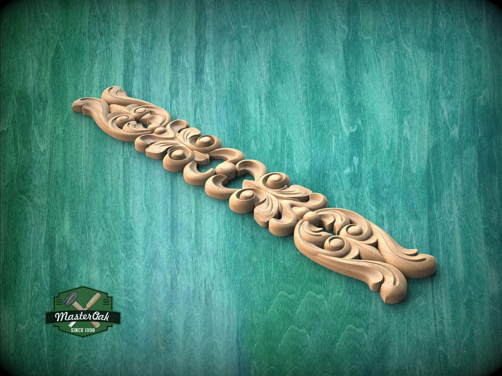 A decorative wooden carving with intricate floral and scroll designs is displayed against a green textured background.