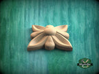 A wooden flower-shaped object is displayed against a green background.
