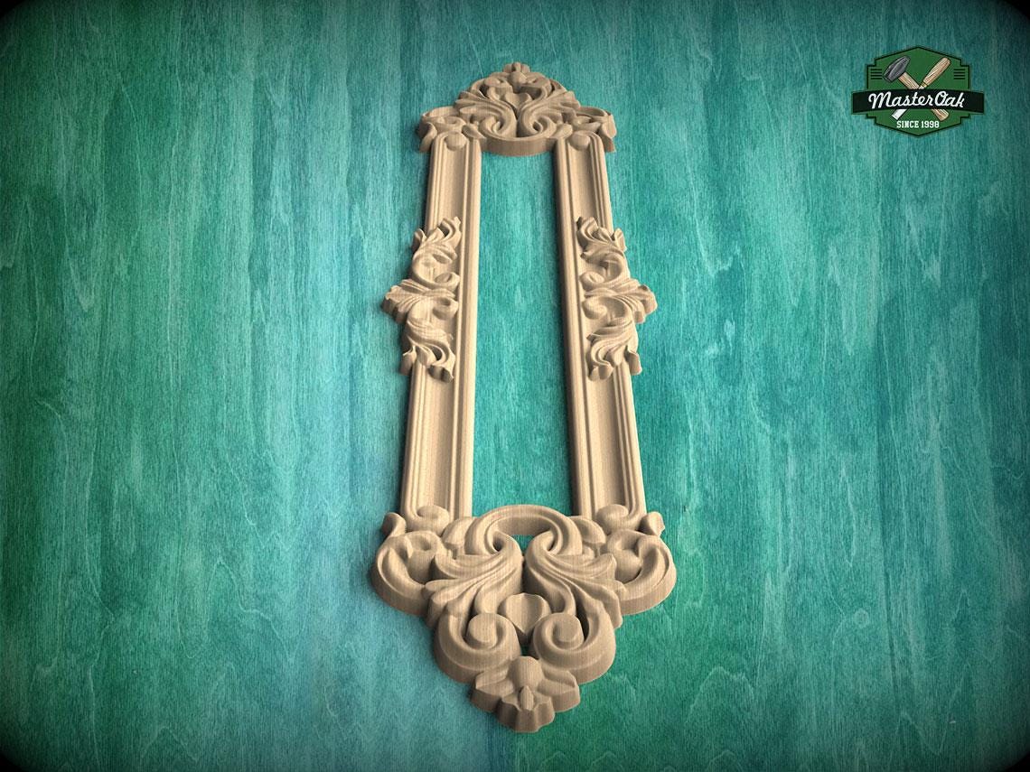 an ornate, carved wooden frame with intricate floral and scrollwork designs, mounted on a green textured wall.