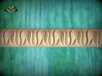 a wooden carving with a curved design on a green background.