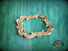 Load image into Gallery viewer, A wooden ornate frame with intricate scrollwork is displayed against a green textured background.

