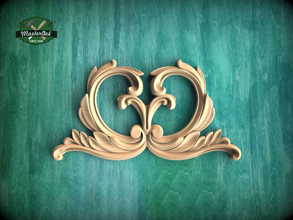 a decorative wooden carving of two ornate, curving shapes on a green background.
