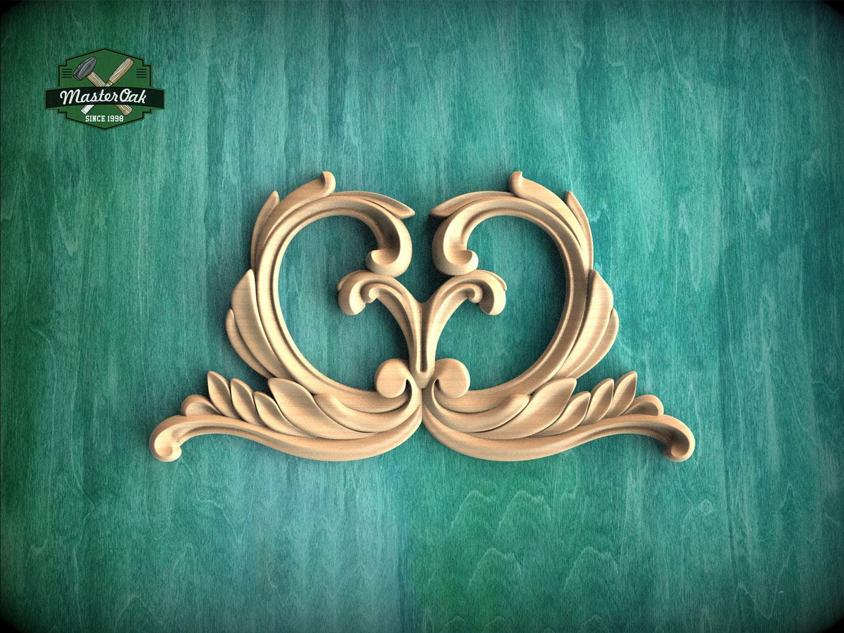 a decorative wooden carving of two ornate, curving shapes on a green background.