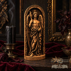 a wooden statue of an angel holding a torch, surrounded by a red velvet cloth and a black candle.