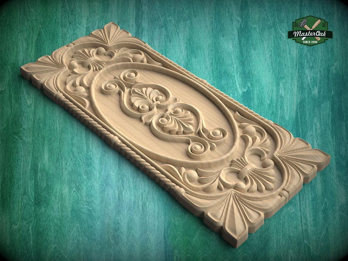 A wooden carving with intricate floral and scroll designs is displayed against a green background.