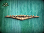 A decorative wooden panel with intricate floral designs is displayed against a textured green background.