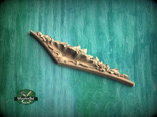 Load image into Gallery viewer, A wooden carving or sculpture with intricate floral designs is displayed against a green textured background.
