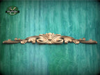 a green wall with a wooden carving on it